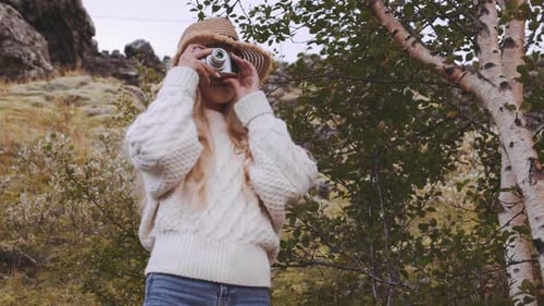 Woman Photographs Natural Scene With Vintage Camera