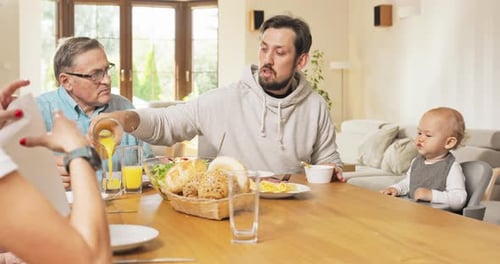 Family and Friends Gather Around Table at Home
