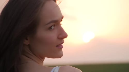 spring fashion portrait of a beautiful happy young woman in white dress with long brown hair on suns