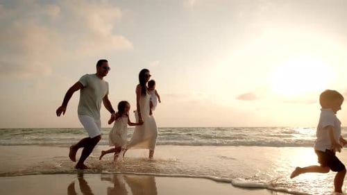 Family Runs on Beach at Sunset