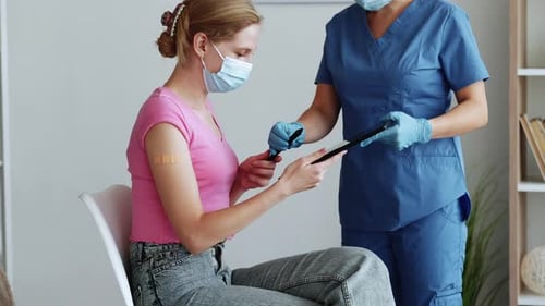 Woman Signs Consent Form After Vaccine at Clinic