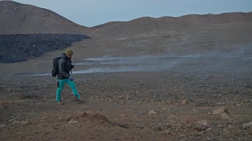 Hiker Exploring Volcanic Landscape with Mountains