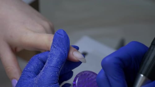 Nail Technician Using Electric File for Manicure