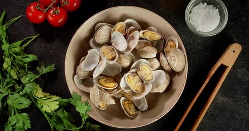Moules à la vongole ouvertes cuites dans une assiette.