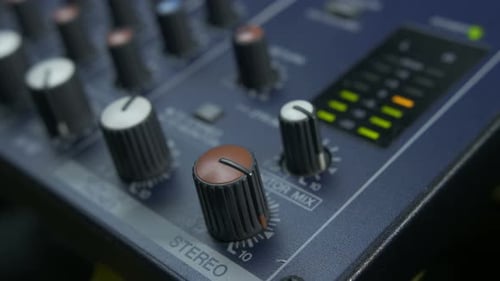 Male Fingers Turning Fader Knob on Audio Mixer