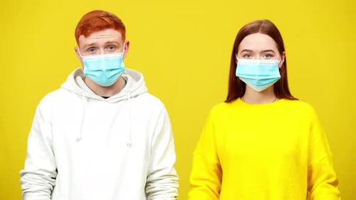Young Adults Remove Masks on a Yellow Background