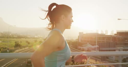 Young woman running on a bridge