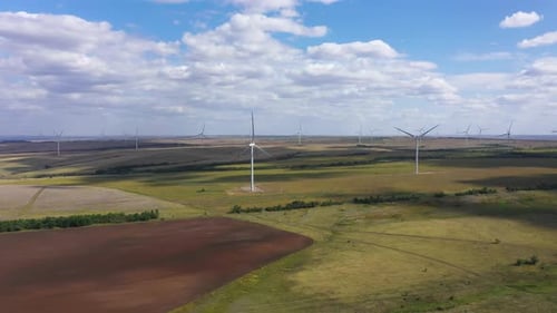 Aerial View Over the Farm Landscape and Wind Turbines Generating Clean Renewable Energy