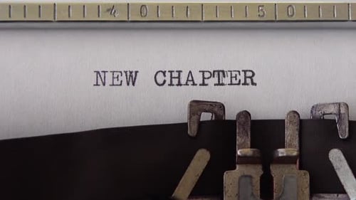 Typing phrase NEW CHAPTER on retro typewriter. Close up.