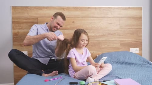 Father Brushing Daughter's Hair at Home with Love