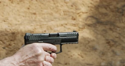Pistole schießt Kugeln in Zeitlupe. Handfeuerwaffen im Schießstand