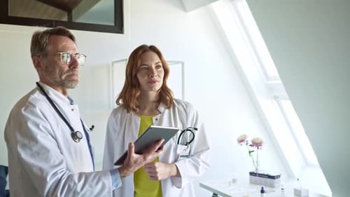 Doctors with digital tablet listening to patient in practice