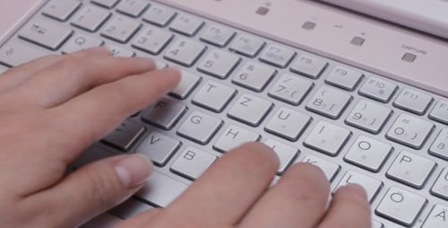 Female fingers typing on laptop keyboard