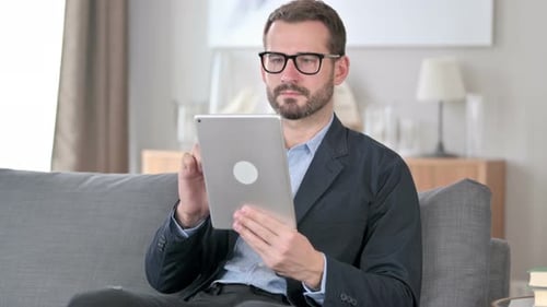 Digital Tablet Use By Attractive Young Businessman at Home