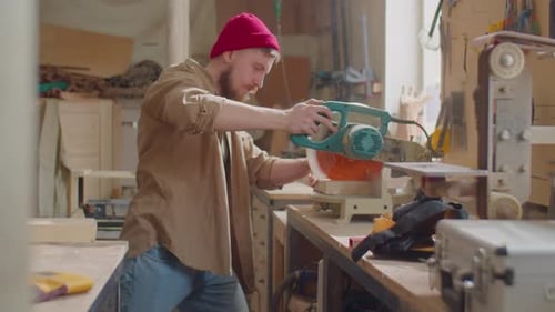 Carpenter Using Power Saw in Workshop