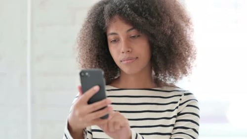 Woman Using Mobile Phone Indoors