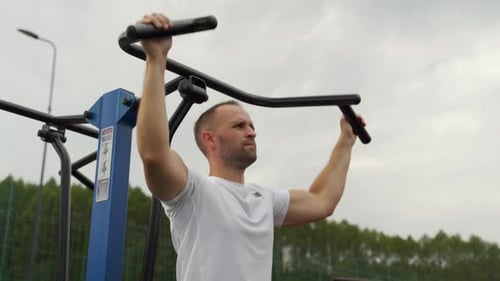 Muscular Man Working Out on Pull-Down Machine Outdoors