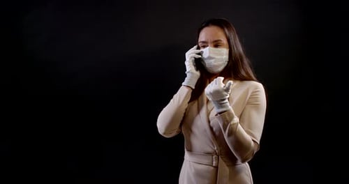 Woman Talking on Phone Wearing Mask and Gloves