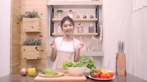 Young Woman Preparing Salad in Kitchen