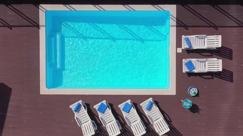 Luxuriöser Pool auf dem Dach des Hauses mit Liegestühlen und Handtüchern für Touristen zum Entspannen