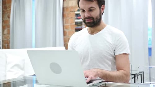 Man Working on Laptop at Home Desk
