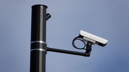 Security Camera Mounted on a Pole Against Sky