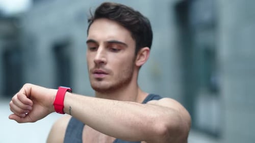 Man Checks Fitness Tracker After Outdoor Workout