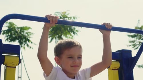 Ein kleiner Junge macht Sport auf dem Spielplatz