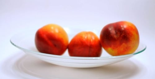 Hand Picking Ripe Nectarines from Fruit Bowl
