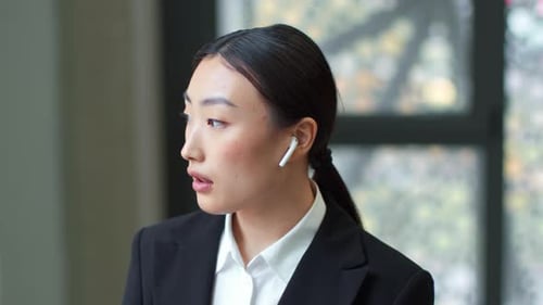 Professional Businesswoman Talking with Wireless Earbuds