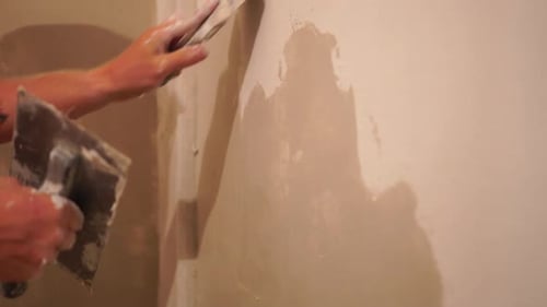 Adult Plastering Wall with Trowel Indoors