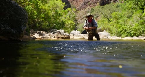 Fisherman fly fishing in river