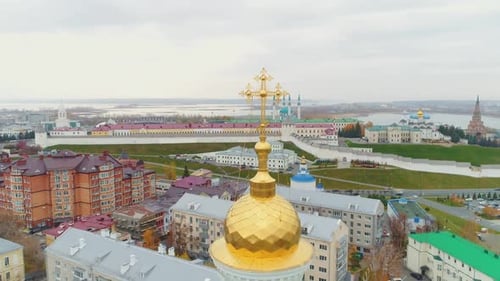 Shiny Gold Cross on Christian Church Dome in Large City