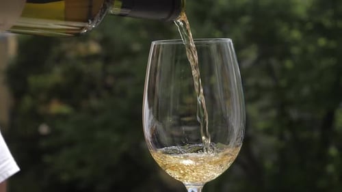 Pouring Refreshing White Wine Into a Glass
