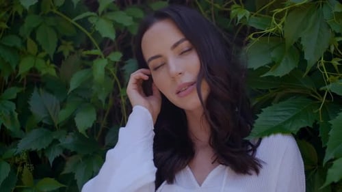 Stylish Hipster Girl Posing Over Green Leaves Bush Background