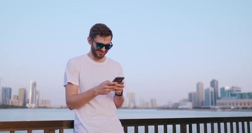 Young Man Using Cell Phone in Urban Setting