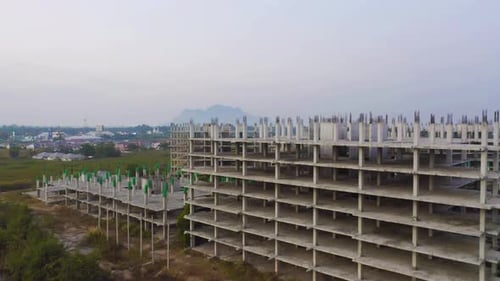 Aerial top view of abandoned apartment or hotel under construction site with structure.