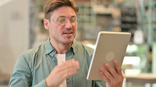 Adult Man Video Chatting on a Tablet