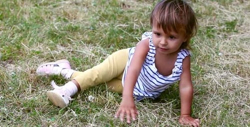 Cute Girl Playing on Grassy Lawn in Sunlight