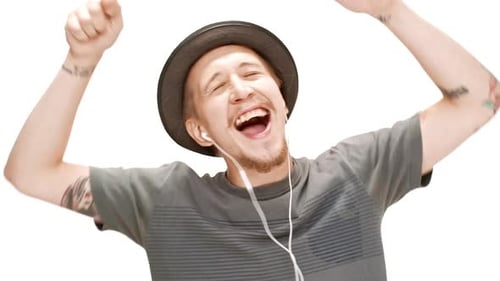 Young Handsome Man in Hat Smiling Singing Dancing Listening Music in Headphones Over White