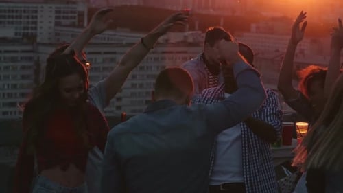 Friends Dancing on Rooftop at Sunset Party