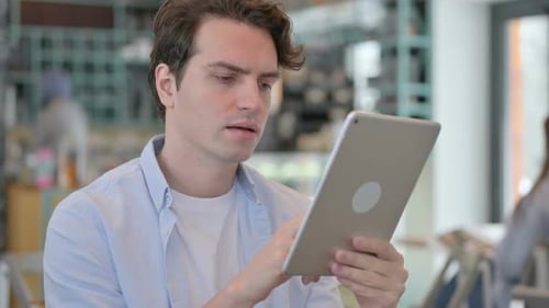 Young Adult Using Tablet Indoors During Daytime