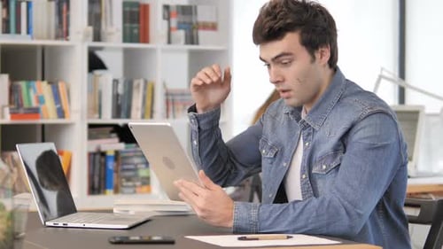 Frustrated Man Using Tablet in Home Office