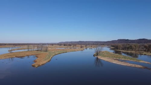 Breite Luftaufnahme des Flusses mit kleinen Landinseln mit Bäumen. Bluffs im Hintergrund.