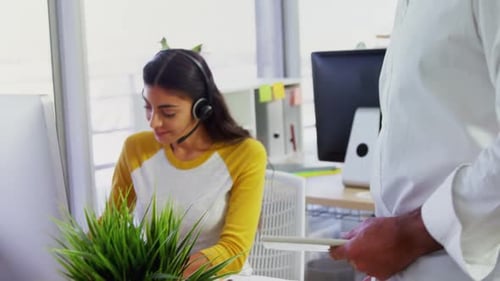 Executive mit Headsets über Computer am Schreibtisch im Büro 4k