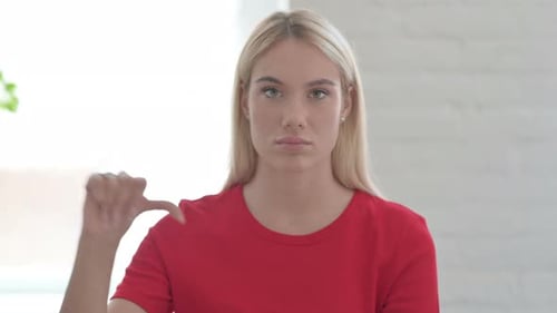 Young Woman Gives Thumbs Down Gesture