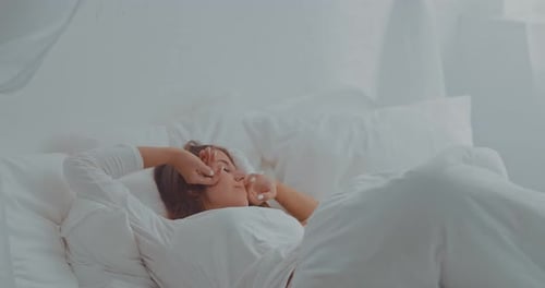 Woman Wakes Up and Stretches in Bed