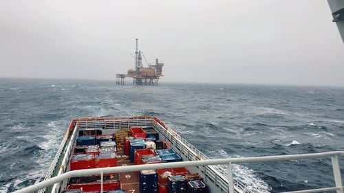 Platform Supply Vessel PSV Near Oil Rig and Drilling Platform