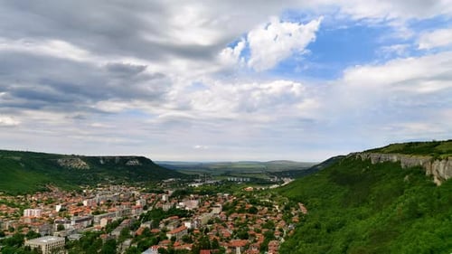 Picturesque City Nestled Between Green Mountain Ranges