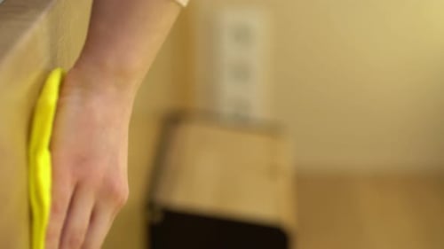 Hand Wiping Wood Surface with Yellow Cloth